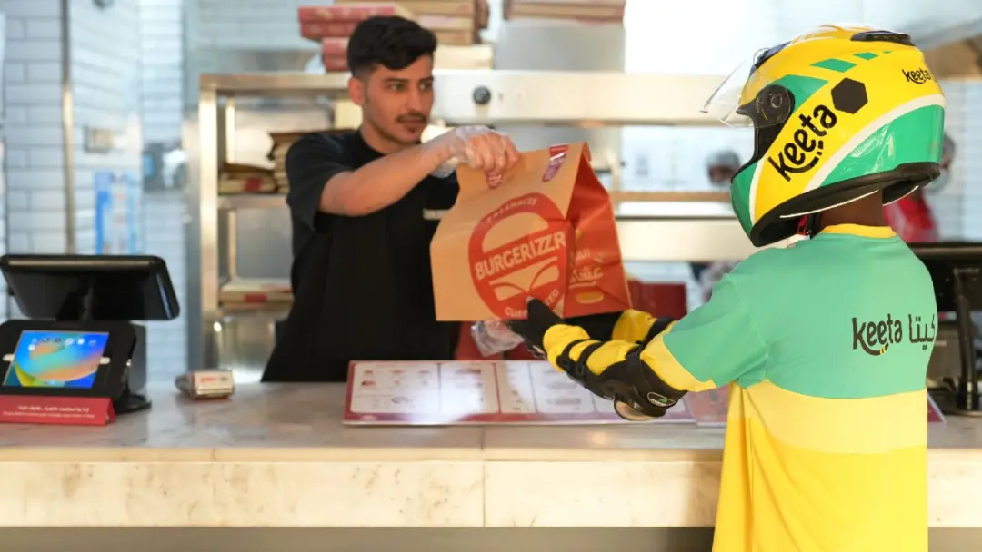 ▲Keeta外賣員在沙特當(dāng)?shù)夭惋嬮T店取餐 圖源：美團(tuán)官網(wǎng)